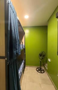a room with green walls and a fan at Hostel BM19 in Madrid