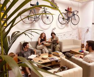 a group of people sitting in a living room with a bike on the wall at Bed & Bike Barcelona in Barcelona