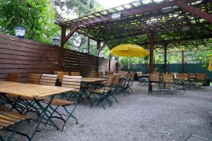 a group of tables and chairs with a yellow umbrella at Hotel - Restaurant Valley Rose in Vienna