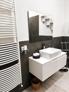 a white bathroom with a sink and a mirror at Seicuori Padova - 2 Camere, 2 Bagni, Parcheggio in Padova