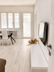 a living room with a television and a table at Seicuori Padova - 2 Camere, 2 Bagni, Parcheggio in Padova +16 photos