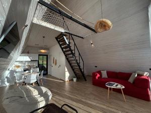 ein Wohnzimmer mit einem roten Sofa und einer Treppe in der Unterkunft Space Trip Hotel in Artavaz