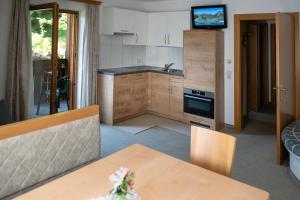 a kitchen with a table and a kitchen with a stove at Apartmenthaus Kuchelberg in Altenmarkt im Pongau