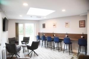 a waiting room with blue chairs and a bar at Coach House Accommodation - Room 6 in Carrick on Shannon