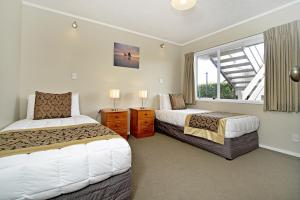 1 dormitorio con 2 camas y ventana en Takapuna Motor Lodge, en Auckland