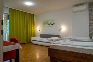a room with two beds and a green curtain at Hotel - Restaurant Valley Rose in Vienna