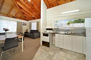a kitchen and living room with a table and a couch at Takapuna Motor Lodge in Auckland