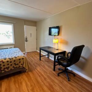a bedroom with a desk and a bed and a chair at Americas Best Value Inn in Danville