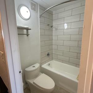 a bathroom with a toilet and a tub and a sink at Americas Best Value Inn in Danville