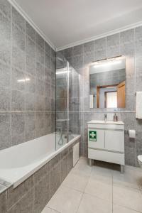 a bathroom with a tub and a sink and a mirror at Cinfães Centro Stay in Cinfães +7 photos