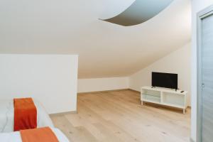 a white room with a tv and a bed at Aura Residence in San Biagio