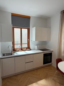 a kitchen with white cabinets and a sink at Street Apartment Rombon in Bovec