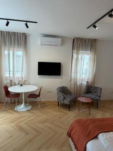 a room with a table and chairs and a tv at Street Apartment Rombon in Bovec