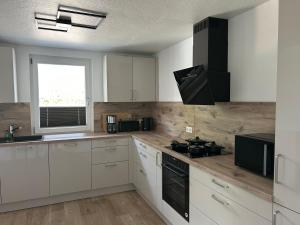 a kitchen with white cabinets and a stove top oven at Ferienhaus Westend in Munster