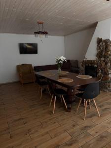 a dining room with a table and chairs and a couch at Guest house Alyaska in Bukovel