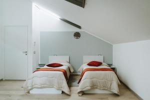 two beds in a room with white walls at Aura Residence in San Biagio +14 photos
