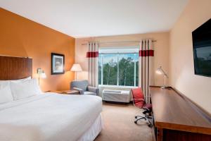 a hotel room with a bed and a desk and a window at Four Points by Sheraton Grande Prairie in Grande Prairie +26 photos