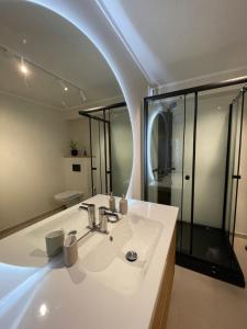 a bathroom with a white sink and a mirror at City Svolvær Apartment in Svolvær