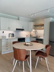 a kitchen with a table and chairs and a refrigerator at City Svolvær Apartment in Svolvær