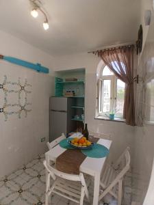 a kitchen with a table with a bowl of fruit on it at L'Angolo Vacation Home in Nerano +12 photos