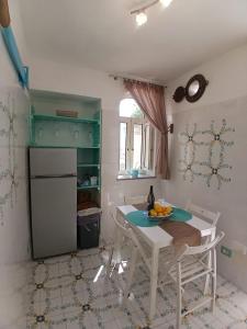 a kitchen with a table with a bowl of fruit on it at L'Angolo Vacation Home in Nerano