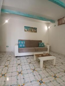 a living room with a couch and a coffee table at L'Angolo Vacation Home in Nerano
