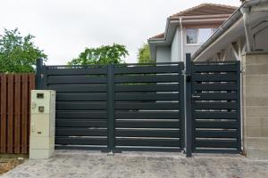 a black gate in front of a house at Sașa s Home Vila Modernă cu Parcare Privată în Timișoara in Timişoara