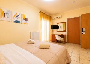 a hotel room with a bed and a desk at La Zagara Rooms - Porto di Milazzo in Milazzo