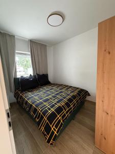 a bedroom with a bed with a yellow and black blanket at Downtown in Bonn