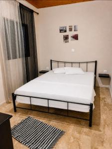 a bedroom with a large bed with white sheets at Pefanis House in Preveza