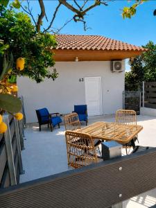 a patio with a table and chairs in front of a house at Pefanis House in Preveza