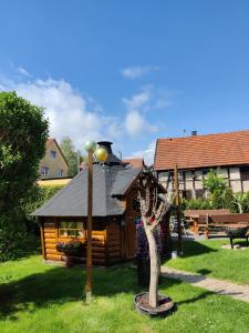 a log cabin in a yard with a tree at Ferienhaus Roseneck Bad Tabarz in Tabarz +3 photos