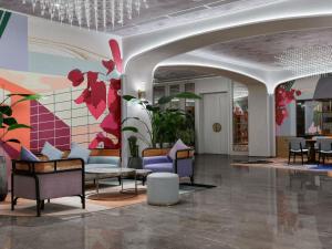 a lobby with chairs and a wall with flowers at Mercure Shenzhen Nanshan in Shenzhen +182 photos