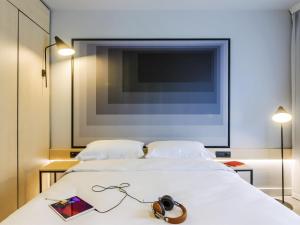a bedroom with two beds and a tv on the wall at ibis Timisoara City Center in Timişoara +75 photos