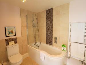 a bathroom with a tub and a toilet and a shower at Kestrel Cottage in Grange Over Sands +34 photos