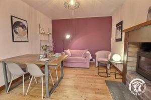 a living room with a table and a pink couch at Ty amzer'zo in Ploulech