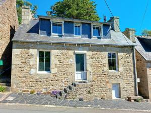 a stone house with a blue roof at Ty amzer'zo in Ploulech