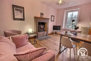 a living room with a couch and a fireplace at Ty amzer'zo in Ploulech