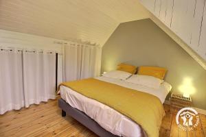 a bedroom with a large bed with an attic at Ty amzer'zo in Ploulech