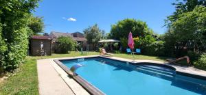 a large swimming pool in a yard with a house at Au 13or intérieur in Champagnolles