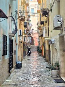 an alley way between two buildings with a scooter driving down it at Il Silenzio del Mare in Gaeta