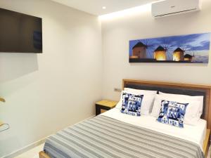 a bedroom with a bed and a flat screen tv at Aroma Zia Residences 2 in Lagoúdi Zía +32 photos