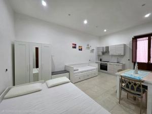 a white kitchen with a bed and a table at Il Silenzio del Mare in Gaeta