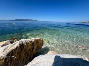 a view of the ocean with rocks in the water at Lana's Apartment in Sarandë