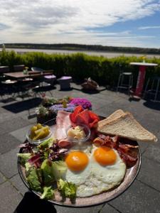 ein Teller mit Frühstücksessen mit Eiern und Brot in der Unterkunft Boutique-Stay in Eberswalde-Finow