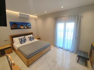 a bedroom with a bed and a large window at Aroma Zia Residences 2 in Lagoúdi Zía