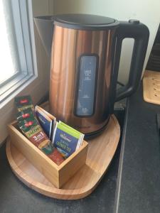 a coffee pot sitting on a wooden tray with books at Milano Apartment in Hamburg