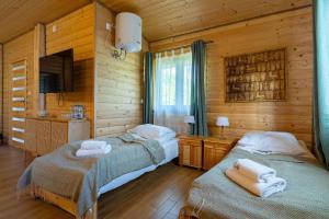 a bedroom with two beds and a television in a cabin at Star-Dadaj Lake Camp in Barczewo +34 photos