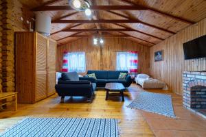 a living room with blue couches and a fireplace at Star-Dadaj Lake Camp in Barczewo