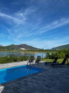 a swimming pool with chairs and a view of the water at Kuća za odmor Ana in Prozor